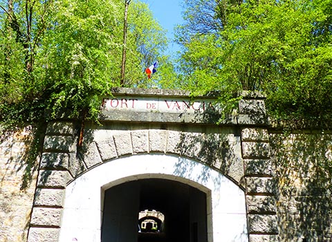 entrée du fort de vancia avec ciel bleu et végétation verte parc vanciaventure lyon rillieux la pape