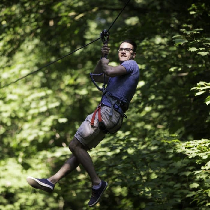 homme sur tyrolienne parcours accrobranche