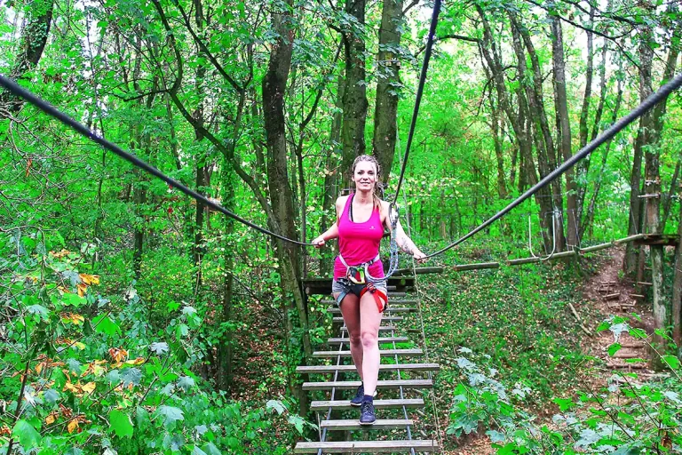 jeune femme sur la passerelle d'un parcours accrobranche en forêt au nord de lyon