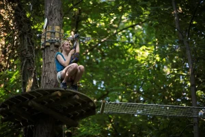 jeune femme s'apprête à se lancer en tyrolienne dans l'accrobranche du fort de vancia