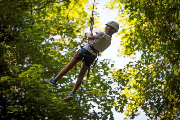enfant avec casque sur une tyrolienne dans le parc accrobranche vanciaventure