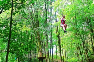 une jeunne femme se lance sur la grande tyrolienne du fort de vancia au nord de lyon